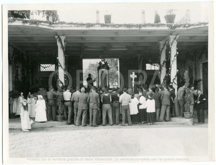[94522] La folla è vista di spalle all'interno del cortile del Lanificio attorno alla Madonna e il parroco parla rivolto verso i fedeli.