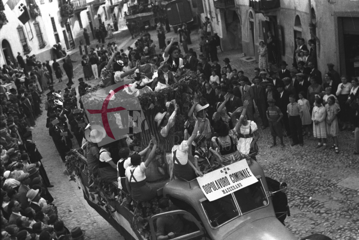 Masserano, anni ‘30. Festa dell’Uva. Il carro allegorico dell’Opera Dopolavoro Comunale del paese saluta i gerarchi fascisti affacciati al balcone della Casa del Fascio di via Roma (Archivio Cesare Valerio – Proprietà Fondazione Cassa di Risparmio di Biella)