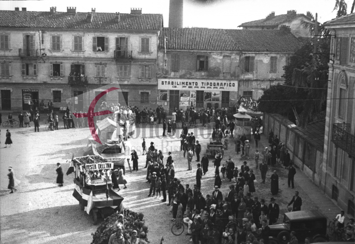 Biella, anni ‘30. Festa dell’Uva. Carri allegorici sfilano in “piassa d’la Dus” (piazza Alessandro La Marmora). Gli edifici sullo sfondo saranno abbattuti alla fine del decennio successivo per permettere il prolungamento di via Pietro Micca fino a via Alfonso La Marmora e la creazione del Quartiere degli Affari (Archivio Cesare Valerio - Proprietà Fondazione Cassa di Risparmio di Biella)