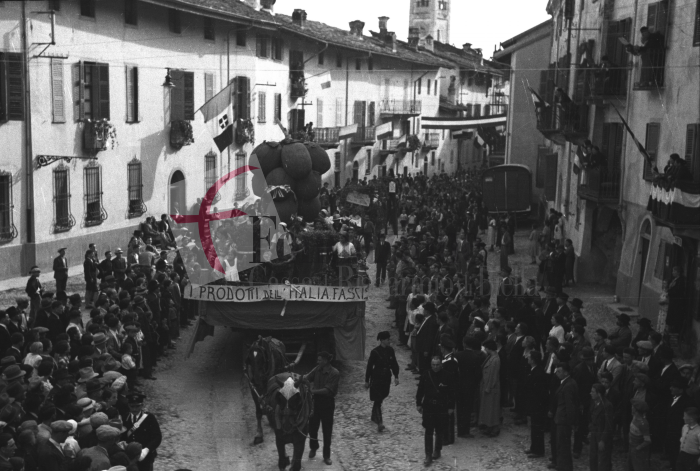 Masserano, anni ‘30. Festa dell’Uva. Il carro allegorico dell’Opera Dopolavoro Comunale di Gattinara celebrante “i prodotti dell’Italia fascista” sfila lungo via Roma (Archivio Cesare Valerio – Proprietà Fondazione Cassa di Risparmio di Biella)