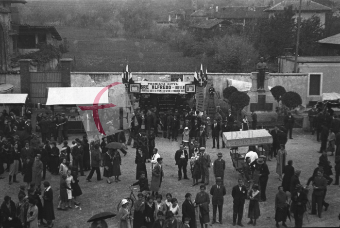 Chiavazza, 8 ottobre 1933. Festa dell’Uva. Piazza Vittorio Emanuele (l’attuale piazza XXV Aprile) invasa dai chioschi per la vendita e la degustazione di uva. Al centro, a sinistra del monumento ai Caduti della Prima Guerra Mondiale (inaugurato nel 1923), spicca il banco della Ditta Alfredo Bre di Biella, «produttrice diretta di vini ed uve in Mongardino d’Asti» (Archivio Cesare Valerio - Proprietà Fondazione Cassa di Risparmio di Biella)