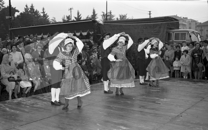 Biella, 4 ottobre 1964. Sagra Provinciale dell’Uva. Il Gruppo Folkloristico della “Pietro Micca” esegue alcuni balli caratteristici del Piemonte sul palco allestito nel piazzale antistante i Giardini Zumaglini. La vecchia stazione della Biella-Santhià era stata demolita solo tre anni prima (Archivio Lino Cremon - Proprietà Fondazione Cassa di Risparmio di Biella)