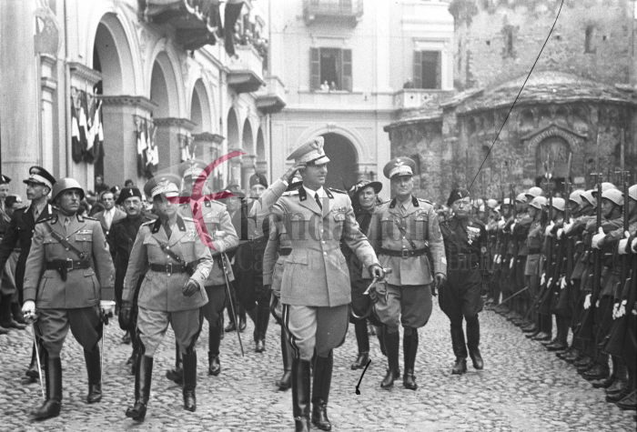 Biella, 17 giugno 1936. Il principe Umberto di Savoia in via Battistero, accompagnato dal Maresciallo d'Italia Rodolfo Graziani (dietro, a destra). Tra gli altri si riconoscono il gerarca Baldassarre Trabucco e il Consigliere Nazionale Leone Garbaccio (a sinistra, entrambi con il fez). Foto C. Valerio (proprietà Fondazione Cassa di Risparmio di Biella)