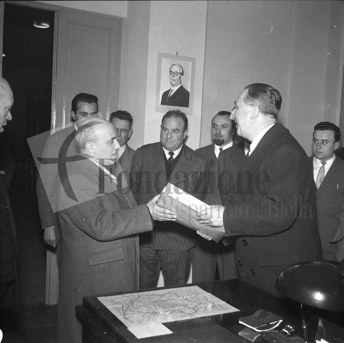 Biella, primavera 1956. Giuseppe Pella dona al segretario della Democrazia Cristiana Amintore Fanfani in visita in città i primi due tomi degli Acta Reginae Montis Oropae. Foto L. Cremon (proprietà Fondazione Cassa di Risparmio di Biella)