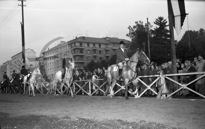 Biella, 4 ottobre 1964. Sagra Provinciale dell’Uva. Cavalieri e amazzoni della scuola di equitazione Città di Biella, diretta dal signor Aondio, sfila nel campo allestito nel piazzale di via La Marmora (Archivio Lino Cremon - Proprietà Fondazione Cassa di Risparmio di Biella)