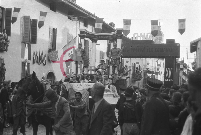 Masserano, 26 settembre 1937. VIII Festa Provinciale dell’Uva. Un carro dedicato alla “Dea Uva” sfila sotto l’arco trionfale che gli organizzatori collocarono all’inizio di via Roma. La Festa dell’Uva di Masserano avveniva regolarmente dall’inizio degli anni ’30, ma nel 1937 (così come già nel 1935) assunse carattere provinciale con la presenza delle massime autorità del territorio (Archivio Cesare Valerio – Proprietà Fondazione Cassa di Risparmio di Biella)