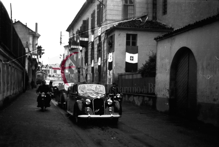Biella, 18 maggio 1939. Benito Mussolini, in visita alla città, sfila lungo l'odierna via Quintino Sella su un'autovettura scoperta, diretto alla chiesa di San Sebastiano dove visiterà la tomba di Alessandro La Marmora.
Foto C. Valerio (proprietà Fondazione Cassa di Risparmio di Biella)